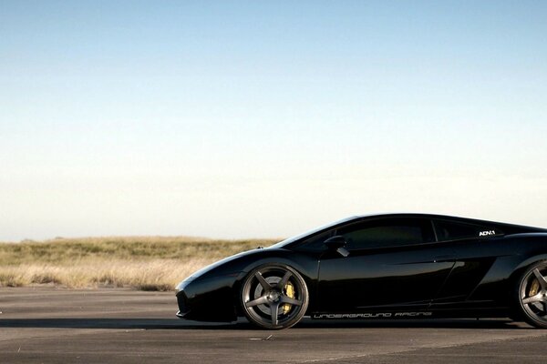 A black lamborghini rushes down the road