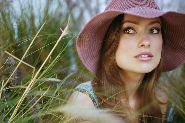 Olivia in a hat on a grass background