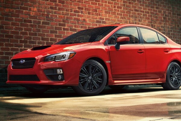 Coche rojo Subaru contra la pared de canela