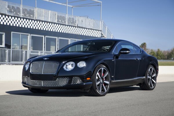 Bentley negro 2013 en la calle al lado del edificio