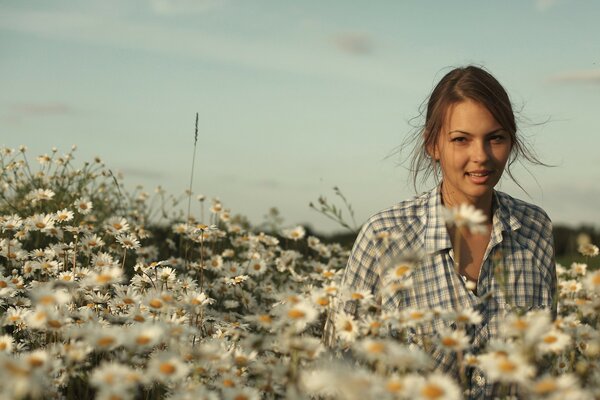 A girl on a chamomile field on a sunny day