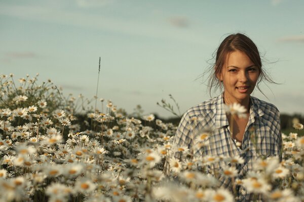 Chica en el campo de manzanilla en un día soleado