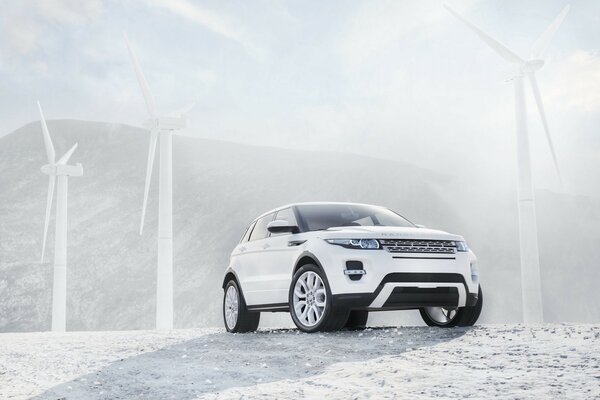 Land rover near wind turbines on a hill background