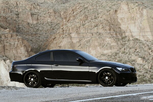 Sur le sentier sur les rochers se tenait une BMW noire