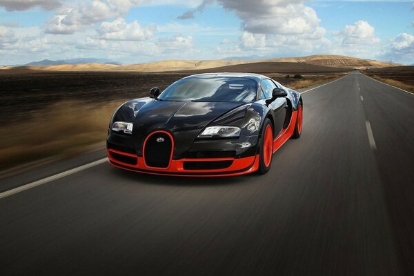 Bugatti Veyron czerwono-czarny pędzi po drodze
