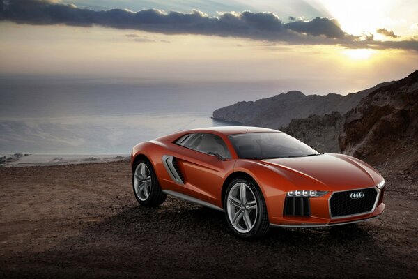 El coche rojo de Audi en el fondo de las rocas