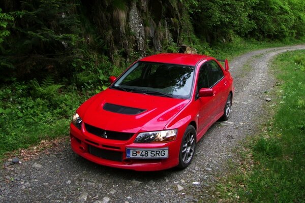 Voiture rouge se trouve sur une route étroite