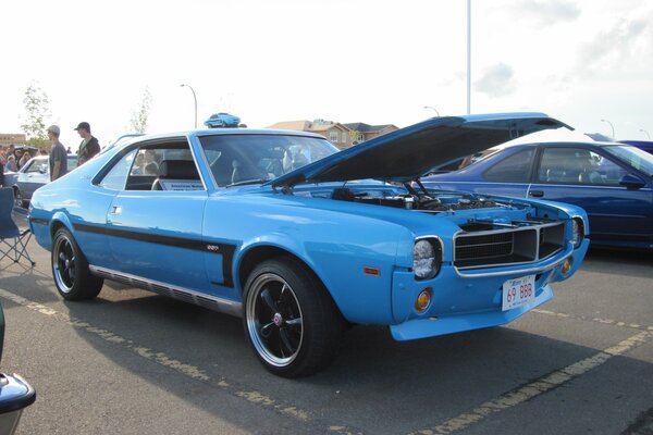 A blue retro car is parked in the parking lot