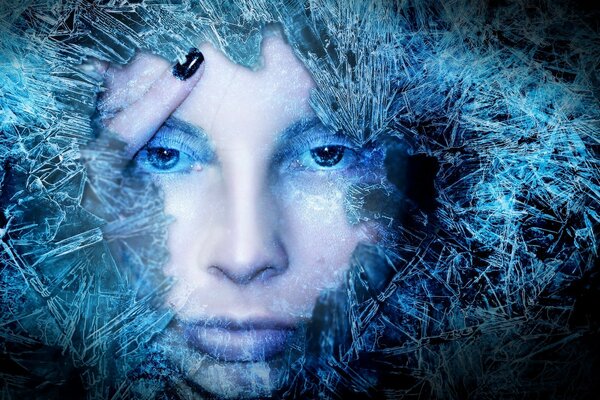 The girl s face framed by ice in blue