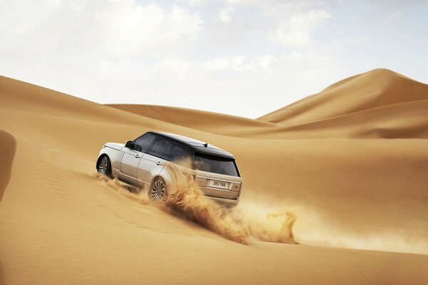 The SUV runs through the yellow desert dunes