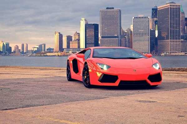 Red Lamborghini supercar on the background of a big city