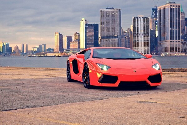 Supercar rouge Lamborghini sur fond de grande ville