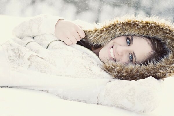 A girl in a white jacket in the snow