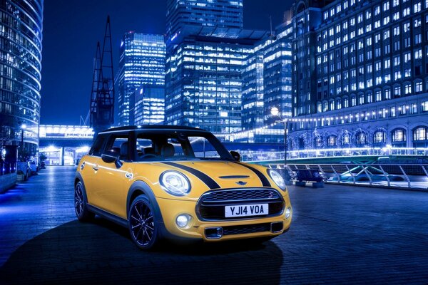 Mini cooper amarillo en la ciudad de la noche