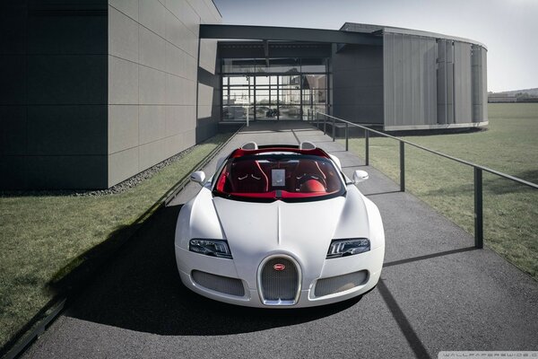 El deportivo blanco Bugatti Veyron contra el telón de fondo de la casa moderna