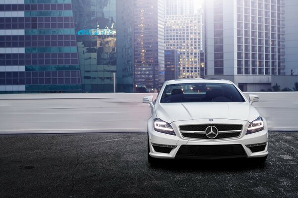 White Mercedes in the parking lot of a modern building