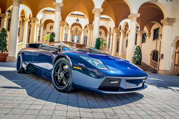 Coche Lamborghini azul en un paisaje Vintage