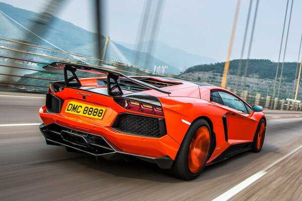 A red Lamborghini is moving along the motorway