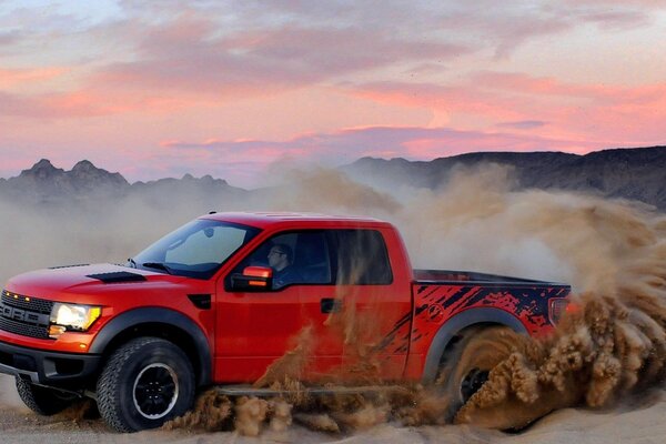 Red SUV Ford drift on the sand