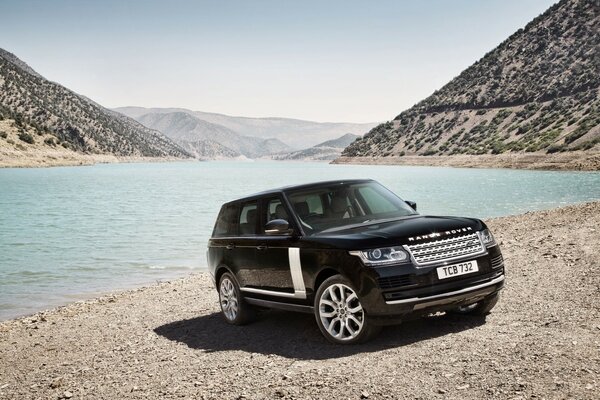 Land Rover on the shore between the hills