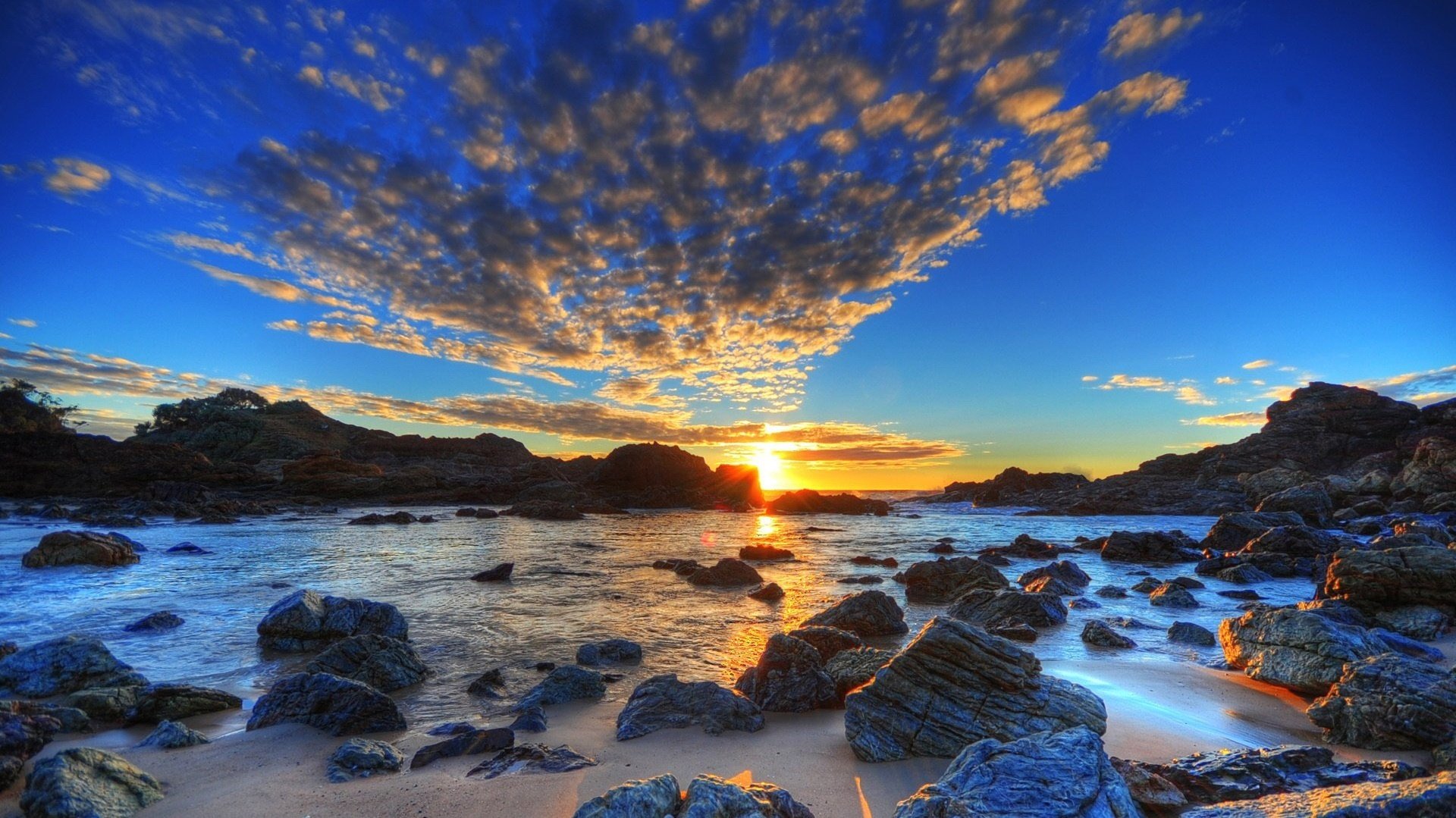 fuente de nubes rocas junto al mar puesta de sol cielo agua paisaje