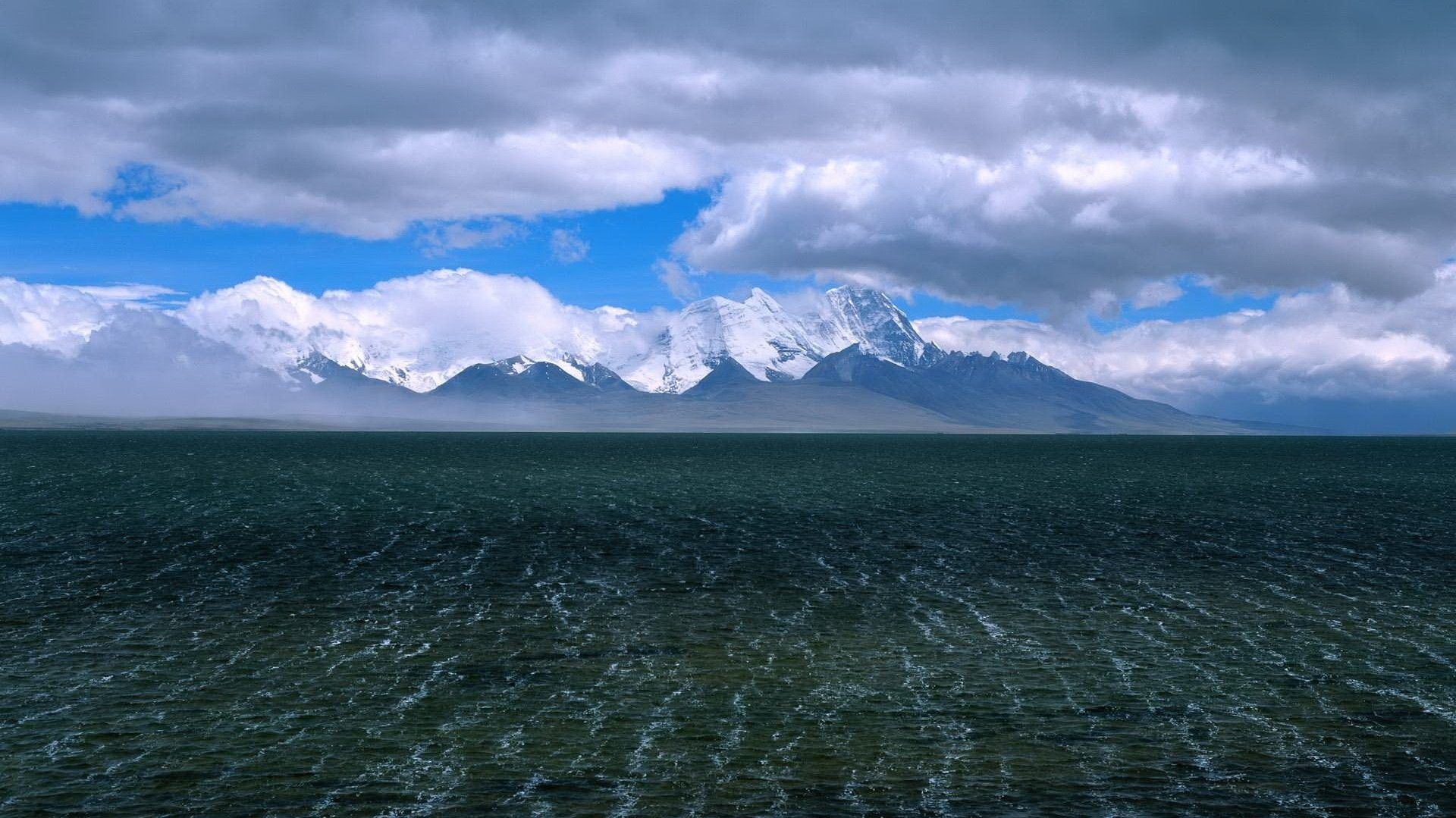 the shimmer of water wave clouds mountains water