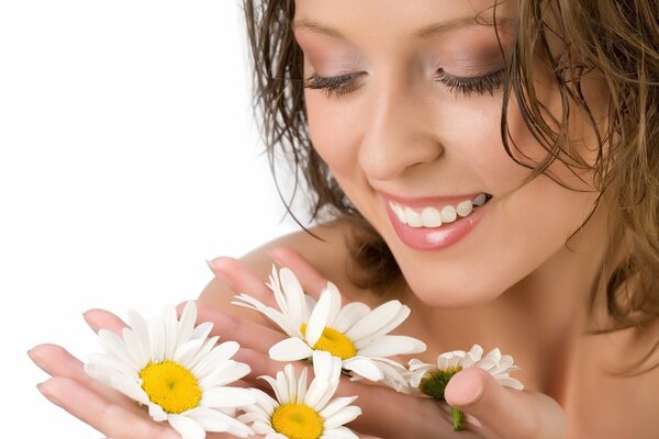 A gentle girl with delicate daisies in her hands