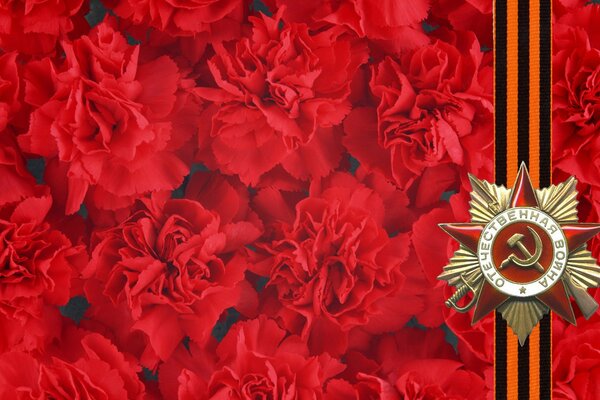 Victory Day postcard with St. George ribbon on a background of scarlet carnations
