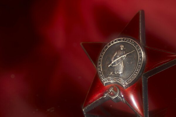 Red star medal for the May 9 holiday on a red background