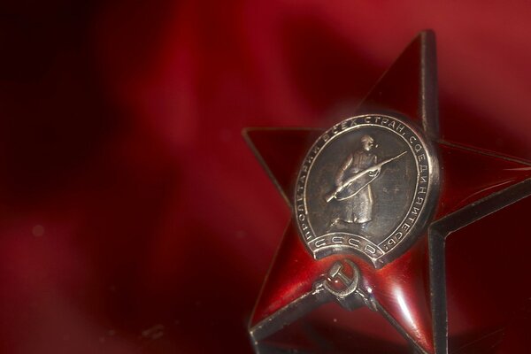 Медаль красная звезда к празднику 9 мая на красном фоне