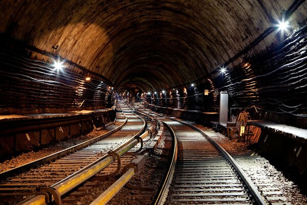 Túnel con electricidad y rieles que van a la distancia