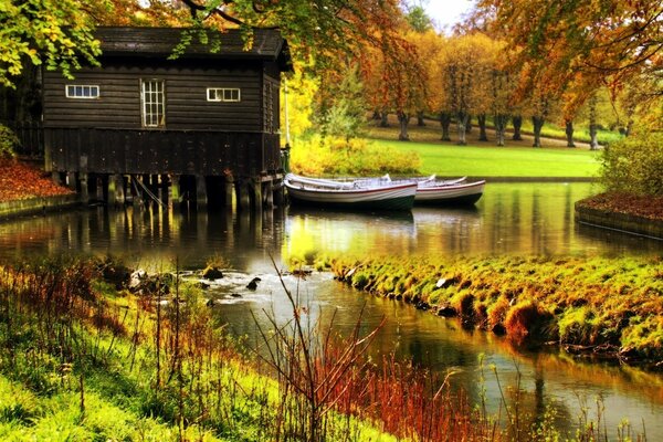 Bright autumn with a house by the water and boats