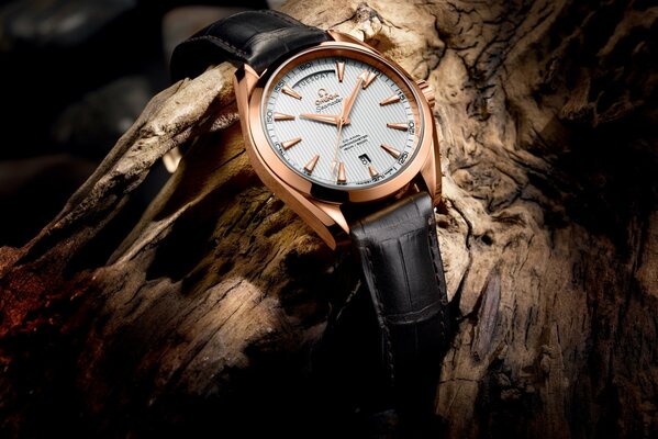 Montre en or avec bracelet en cuir sur bois