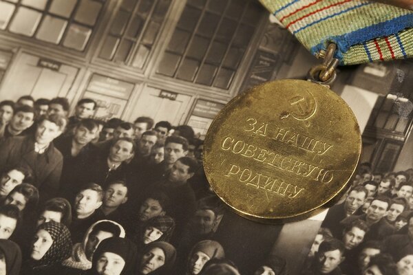 Medal for our Soviet motherland on the background of an old photo of people