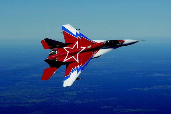 Mehrfarbiger Kampfjet fliegt hoch in den blauen Himmel