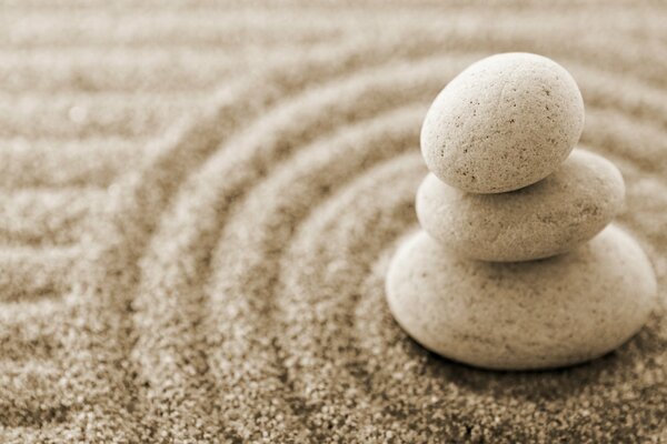 Pyramid of three pebbles, in a circle on the sand