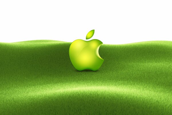 Откусанное яблоко на зеленой траве