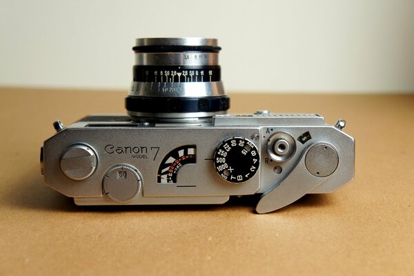 Die Canon 7-Kamera in Silber mit Blitz liegt auf dem Tisch
