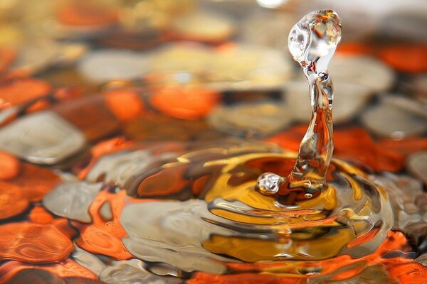 Ein Tropfen Wasser auf bunten Steinen