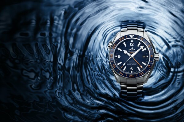 Omega watch on the background of water with waves