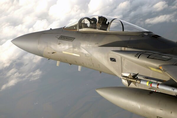 Cabina del piloto de combate en el cielo sobre las nubes