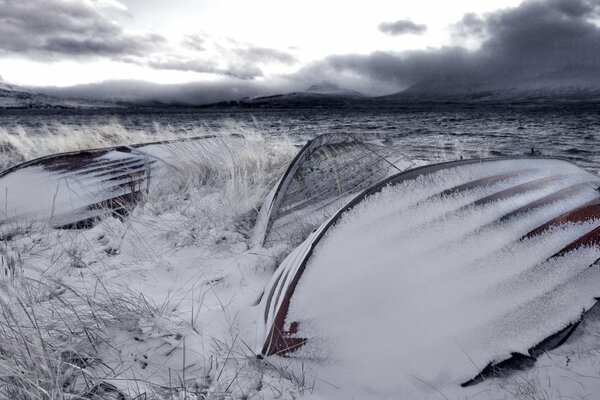 Barcos bajo la nieve contra un cielo oscuro