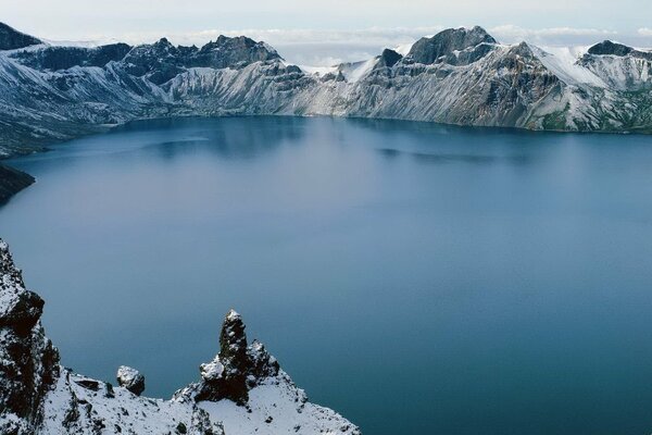 Lago blu nelle montagne innevate