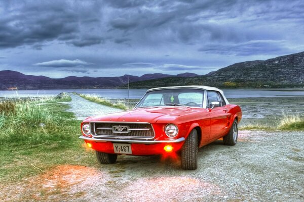 Roter Mustang am See bei bewölktem Wetter