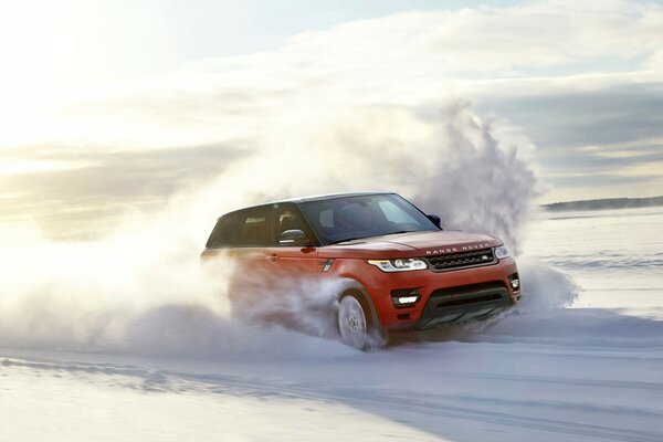 Un auto rossa veloce guida su una strada invernale