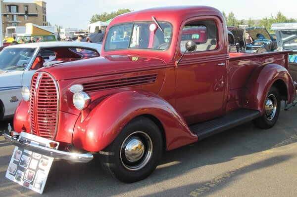 Red Ford truck with photos near the headlights