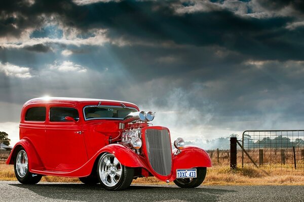 Ford clásico rojo contra un cielo tormentoso