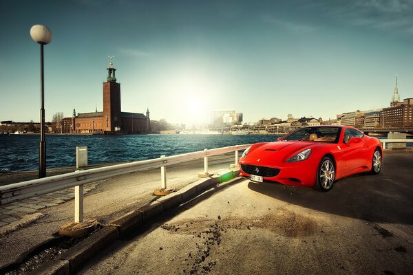 Red Ferari on the background of the river in the city