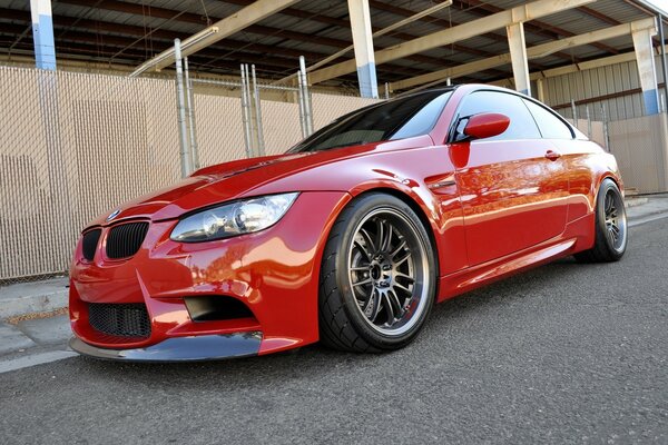 A red BMW car is on the road