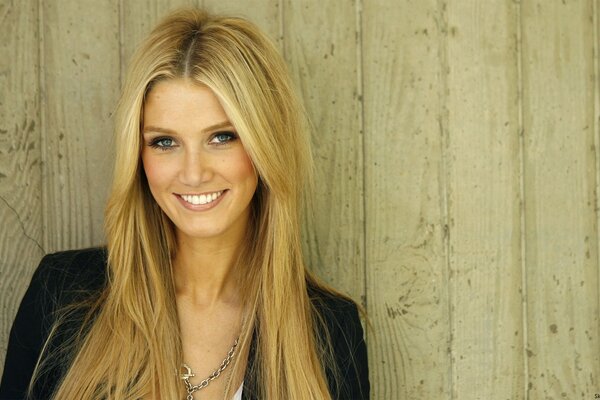 The smile of delta goodrem posing on the background of the boards